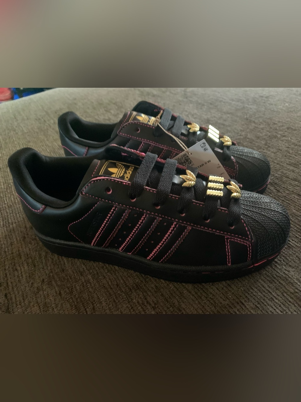 Black and pink Adidas Superstar II W sneakers feature gold trefoil lace